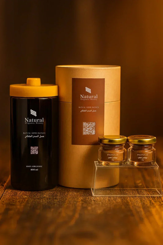 Natural Organic Honey products including 800ml Royal Sidr Honey and two small propolis jars on a wooden surface