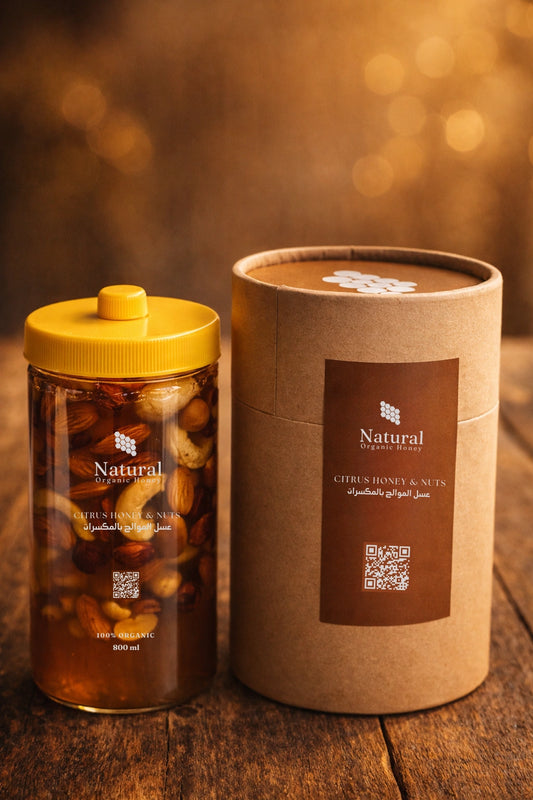 Natural Organic Honey citrus honey with nuts in a clear jar, next to branded brown packaging on wood